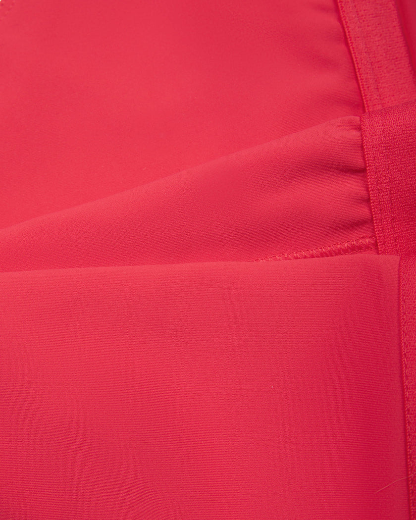 Close-up of the smooth stretch fabric and white contrast trim on the Athlesi TrackLine Edge Sports Bra in red