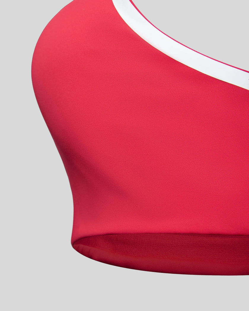 Close-up of the underbust band and fitted hem on the Athlesi TrackLine Edge Sports Bra in red