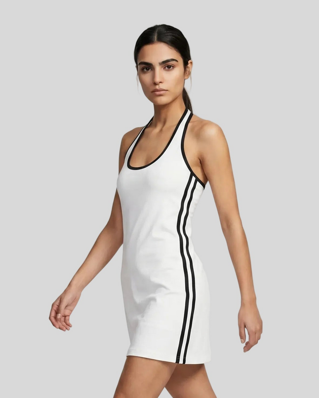 Left angle view of a woman wearing the Athlesi TrackLine Halter Dress in white