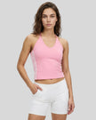 Front angle view of a woman wearing the Athlesi TrackLine Halter Tank in pink and white