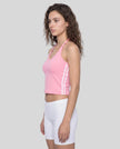 Side view of a woman wearing the Athlesi TrackLine Halter Tank in pink and white