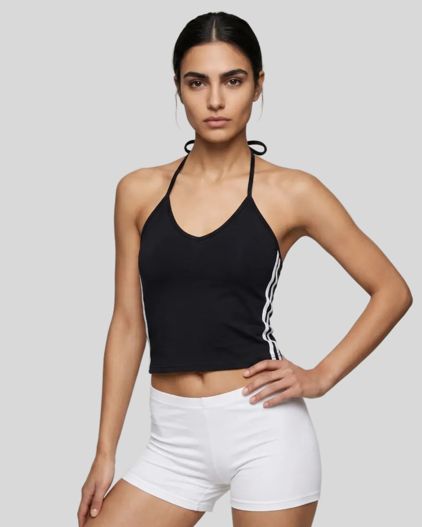 Mid body front view of a woman wearing the Athlesi TrackLine Halter Tank in black and white