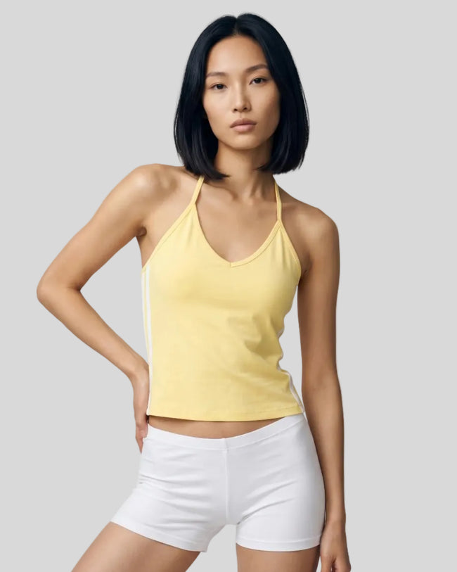 Mid body front view of a woman wearing the Athlesi TrackLine Halter Tank in yellow and white