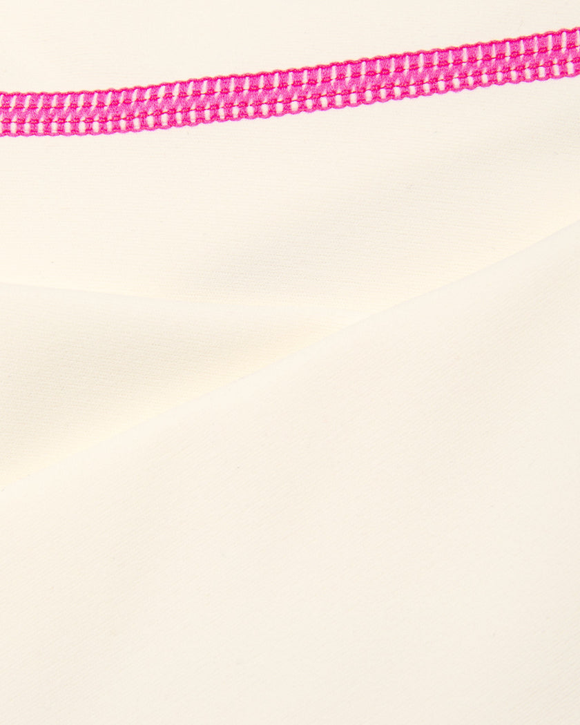 Closeup of smooth stretch fabric and contrast stitching on TrackLine Halter Yoga Top in apricot