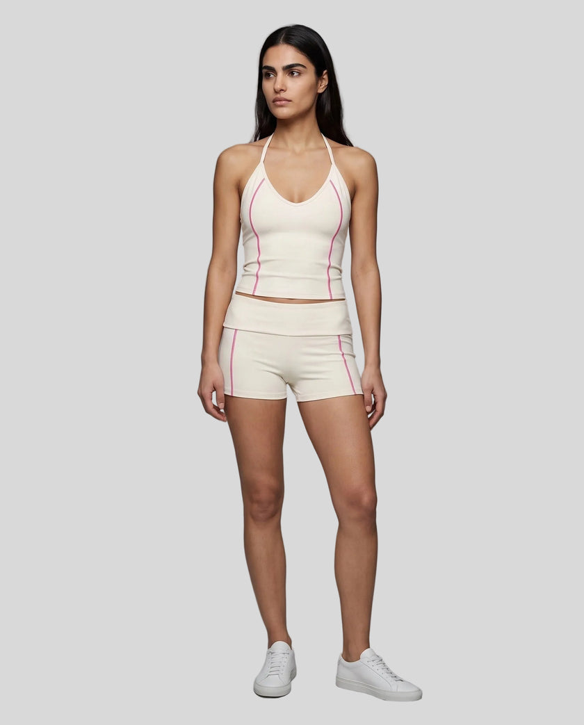 Full body front view of woman wearing apricot TrackLine Halter Yoga Top with matching TrackLine Yoga Shorts
