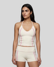 Mid body front view of woman wearing TrackLine Halter Yoga Top in apricot