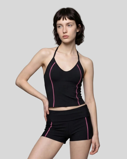 Mid body front view of woman wearing TrackLine Halter Yoga Top in black