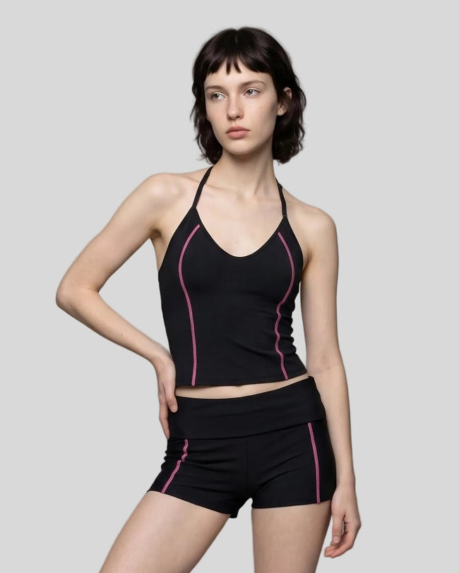 Mid body front view of woman wearing TrackLine Halter Yoga Top in black