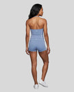 Full body back view of woman wearing blue TrackLine Halter Yoga Top with matching TrackLine Yoga Shorts