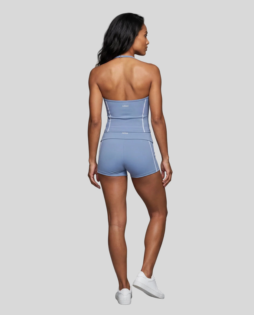 Full body back view of woman wearing blue TrackLine Halter Yoga Top with matching TrackLine Yoga Shorts