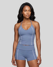 Mid body front view of woman wearing TrackLine Halter Yoga Top in blue