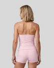 Mid body back view of woman wearing TrackLine Halter Yoga Top in pink