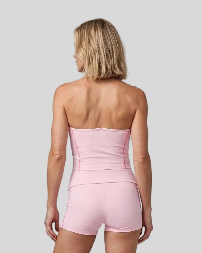 Mid body back view of woman wearing TrackLine Halter Yoga Top in pink