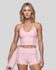 Mid body front view of woman wearing TrackLine Halter Yoga Top in pink