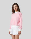 Model wearing the Athlesi TrackLine Heritage Sweatshirt in pink with white contrast trim, front view
