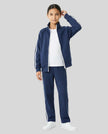 Angled front view of a child wearing the TrackLine Junior Club Jacket in Royal Blue