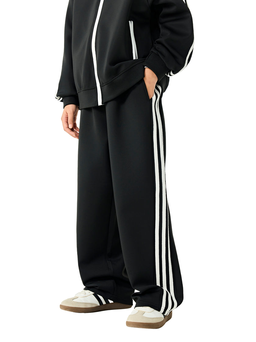 Side angle view of a child wearing the TrackLine Junior Club Pants in Black