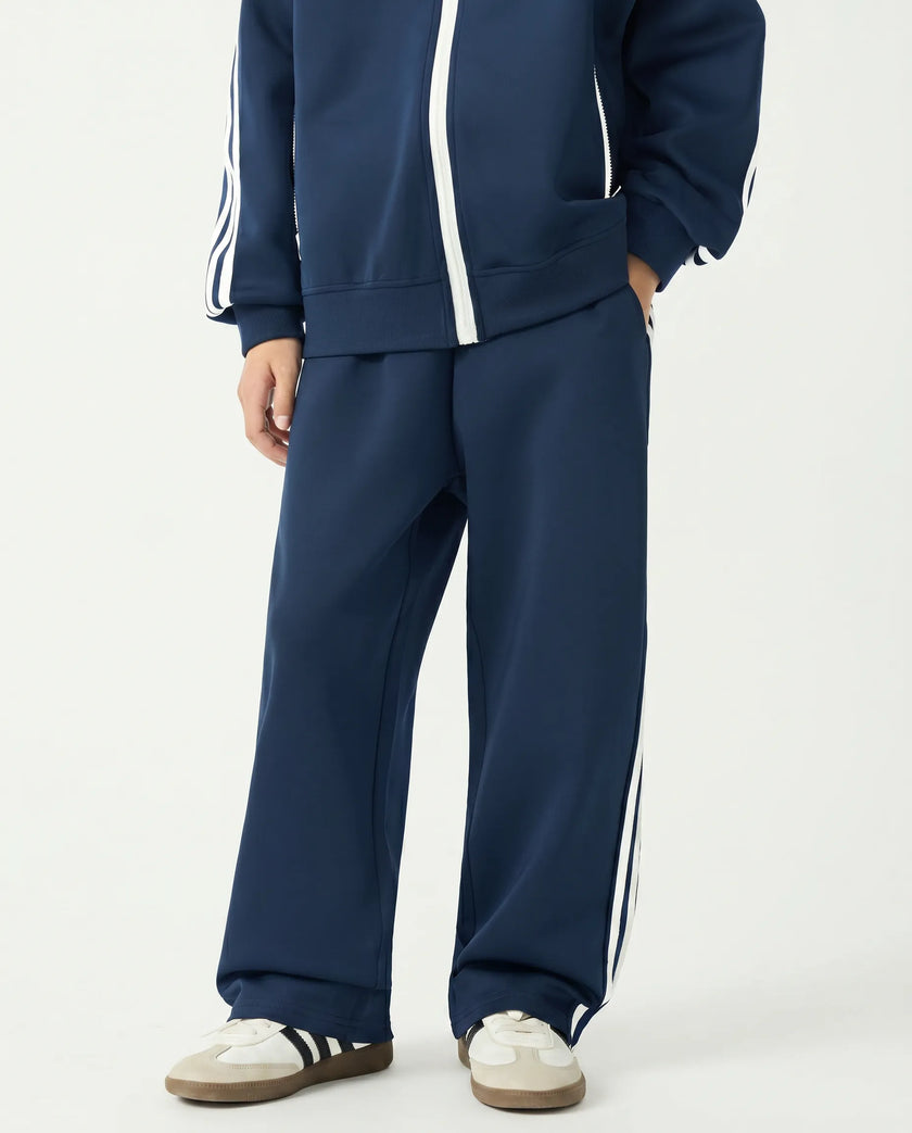Angled front view of a child wearing the TrackLine Junior Club Pants in Royal Blue