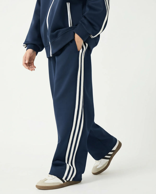 Side view of a child wearing the TrackLine Junior Club Pants in Royal Blue