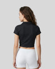 Lower body back styling view featuring the Athlesi TrackLine Lapel Crop Top in black