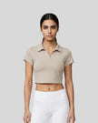 Upper body front view of a woman wearing the Athlesi TrackLine Lapel Crop Top in light coffee
