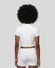 Lower body back styling view featuring the Athlesi TrackLine Lapel Crop Top in white