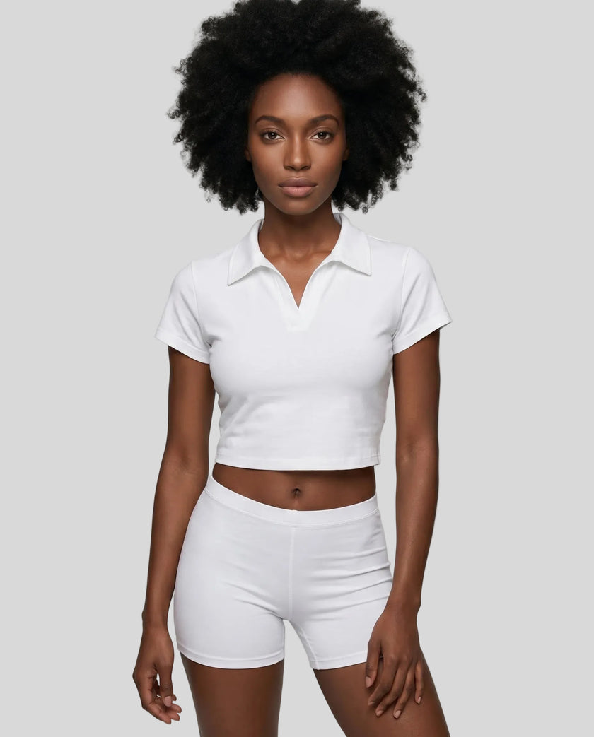 Upper body front view of a woman wearing the Athlesi TrackLine Lapel Crop Top in white