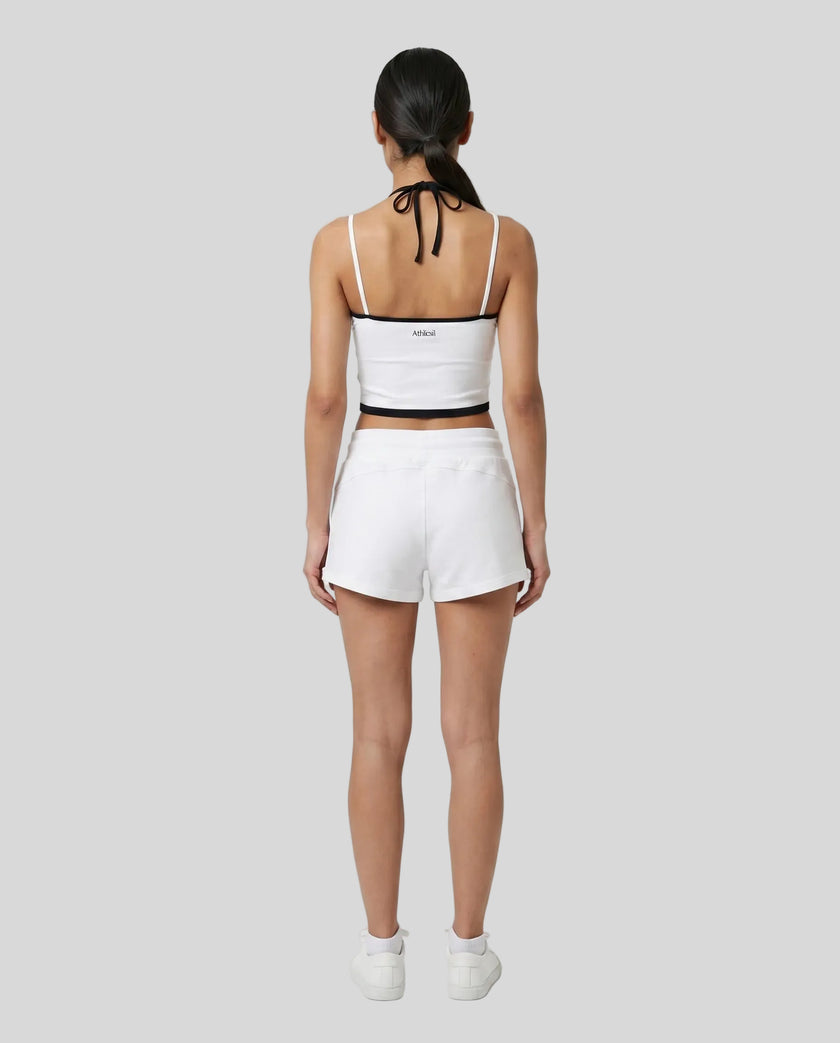 Model wearing TrackLine Lounge Halter Tank in white and black with Trackline Lounge Shorts in white back view