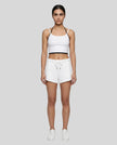 Model wearing TrackLine Lounge Halter Tank in white and black with Trackline Lounge Shorts in white front view