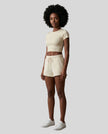 Angled front view of model wearing TrackLine Lounge Tee in apricot with matching Trackline Lounge Shorts