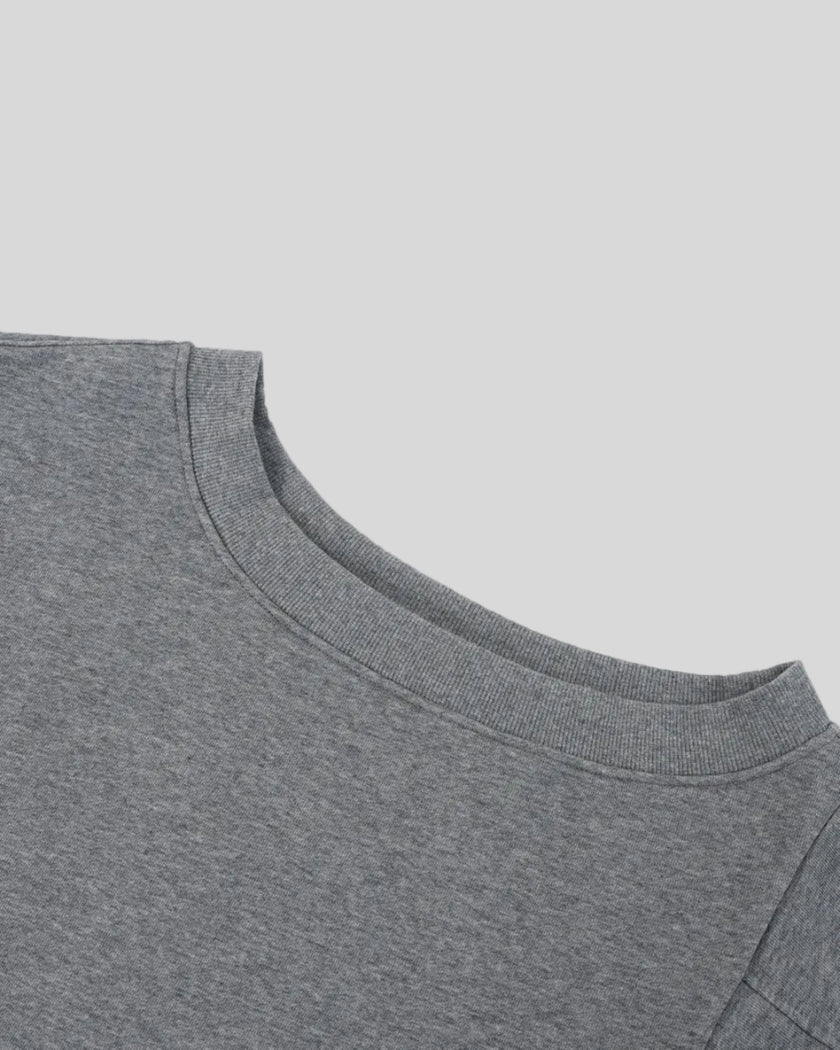 Closeup of the asymmetrical off-shoulder neckline on the Athlesi TrackLine Off-Shoulder Tee in gray