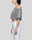 Side view of the Athlesi TrackLine Off-Shoulder Tee in gray showing the relaxed cropped silhouette