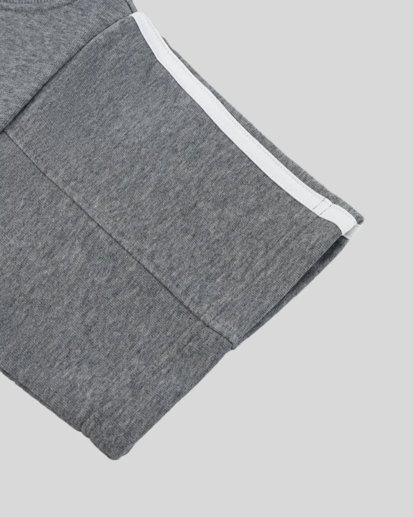 Closeup of the sleeve hem and stripe detail on the Athlesi TrackLine Off-Shoulder Tee in gray