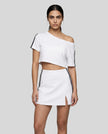 Woman wearing white Trackline Off-Shoulder Tee paired with white Trackline Slit Skirt