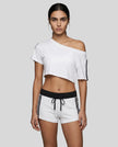 Woman wearing whiteTrackline Off-Shoulder Tee paired with white Trackline Track Shorts