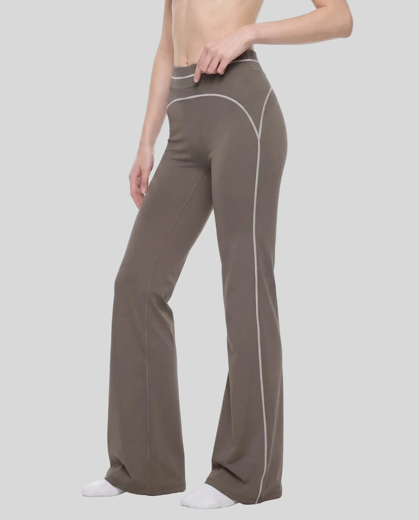 Front angled view of a model wearing the TrackLine Outline Flared Pants in Coffee