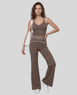 Front angled full body view of a model wearing the TrackLine Outline Flared Pants in Coffee