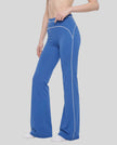 Front angled view of a model wearing the TrackLine Outline Flared Pants in Colorful Blue
