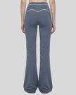 Back view of a model wearing the TrackLine Outline Flared Pants in Haze Blue