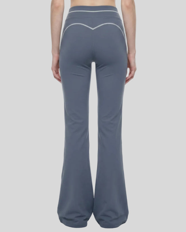 Back view of a model wearing the TrackLine Outline Flared Pants in Haze Blue