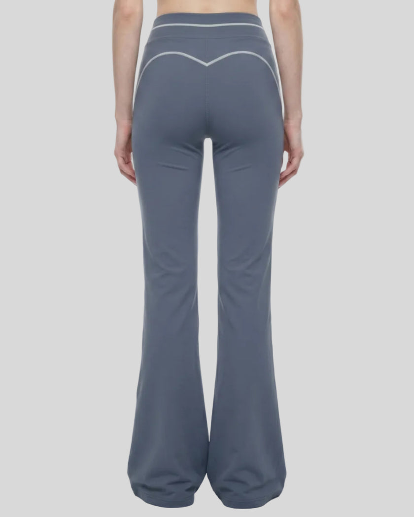 Back view of a model wearing the TrackLine Outline Flared Pants in Haze Blue