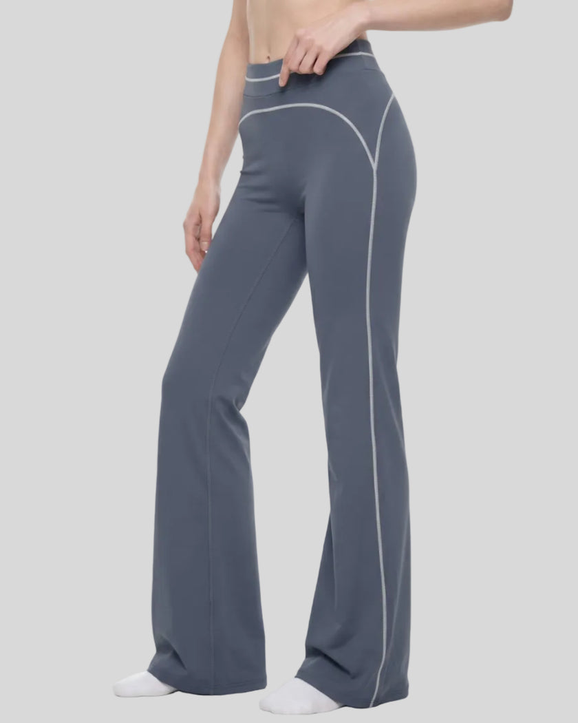 Front angled view of a model wearing the TrackLine Outline Flared Pants in Haze Blue