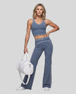 Front angled full body view of a model wearing the TrackLine Outline Flared Pants in Haze Blue