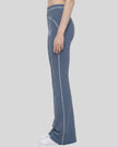 Side view of a model wearing the TrackLine Outline Flared Pants in Haze Blue