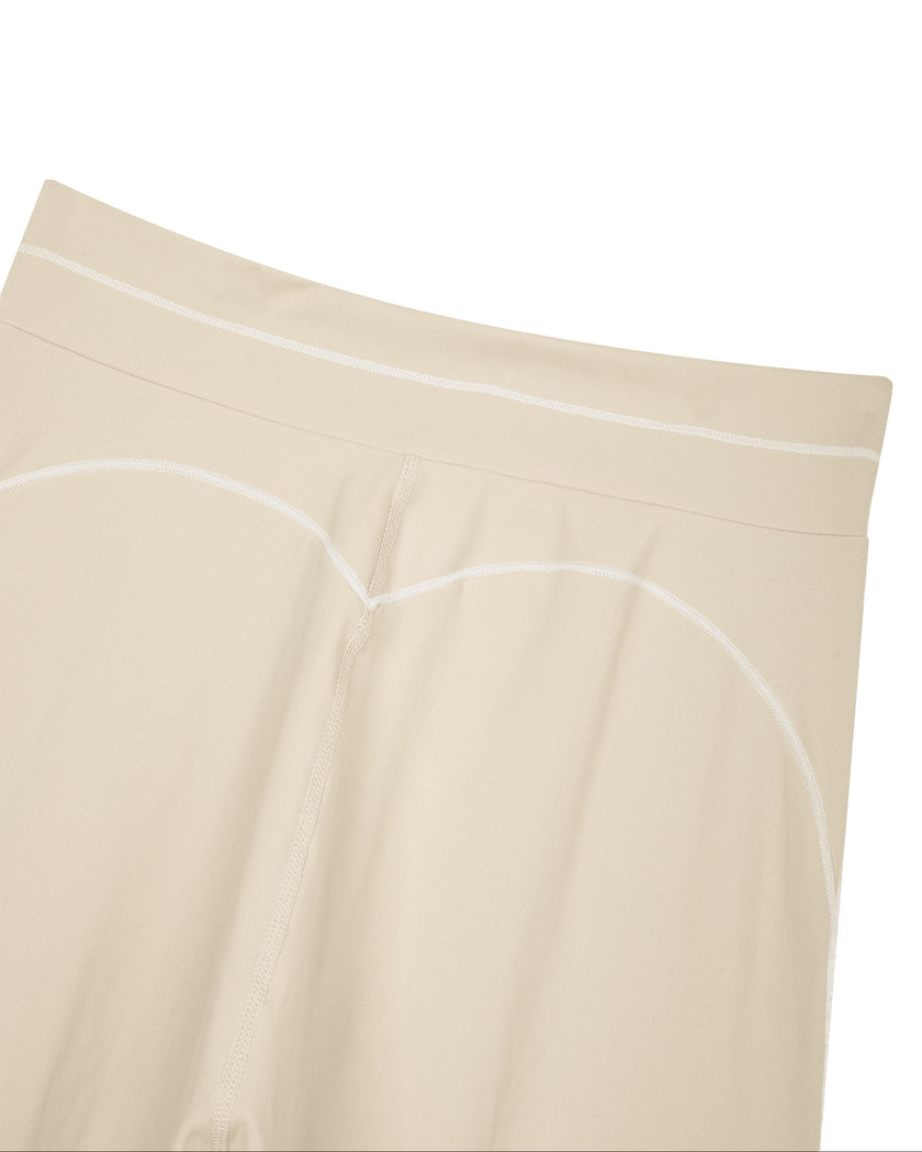 Close-up of the back waistband and contour seam on the TrackLine Outline Flared Pants in Light Apricot