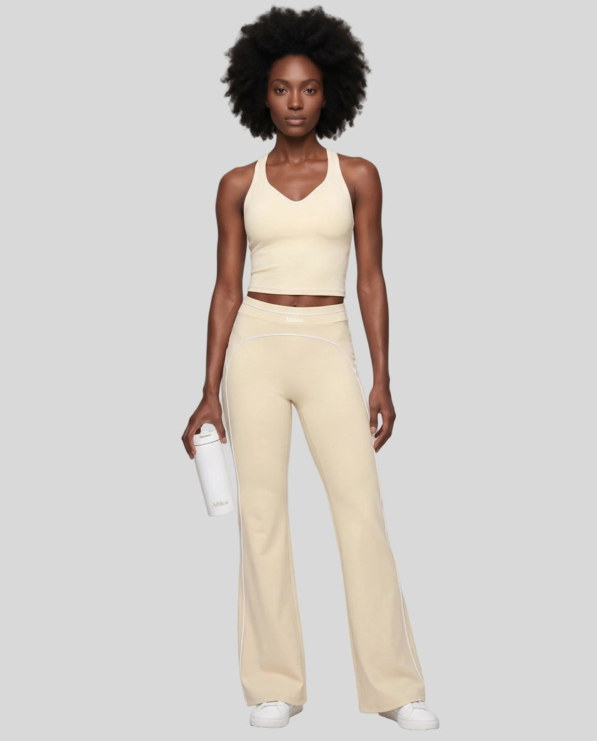 Front angled full body view of a model wearing the TrackLine Outline Flared Pants in Light Apricot