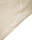 Side close-up of the TrackLine Outline Flared Pants in Light Apricot highlighting the contrast piping detail