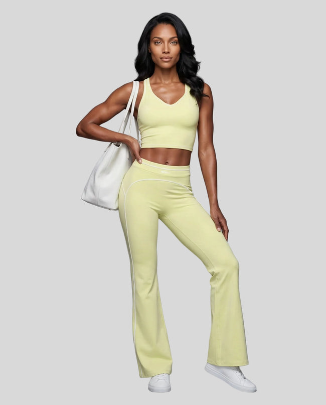 Front angled full body view of a model wearing the TrackLine Outline Flared Pants in Light Green