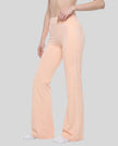 Front angled view of a model wearing the TrackLine Outline Flared Pants in Light Pink