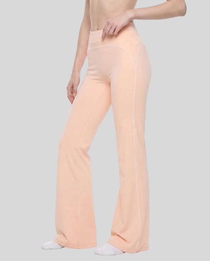 Front angled lower body view of a model wearing the TrackLine Outline Flared Pants in Light Pink